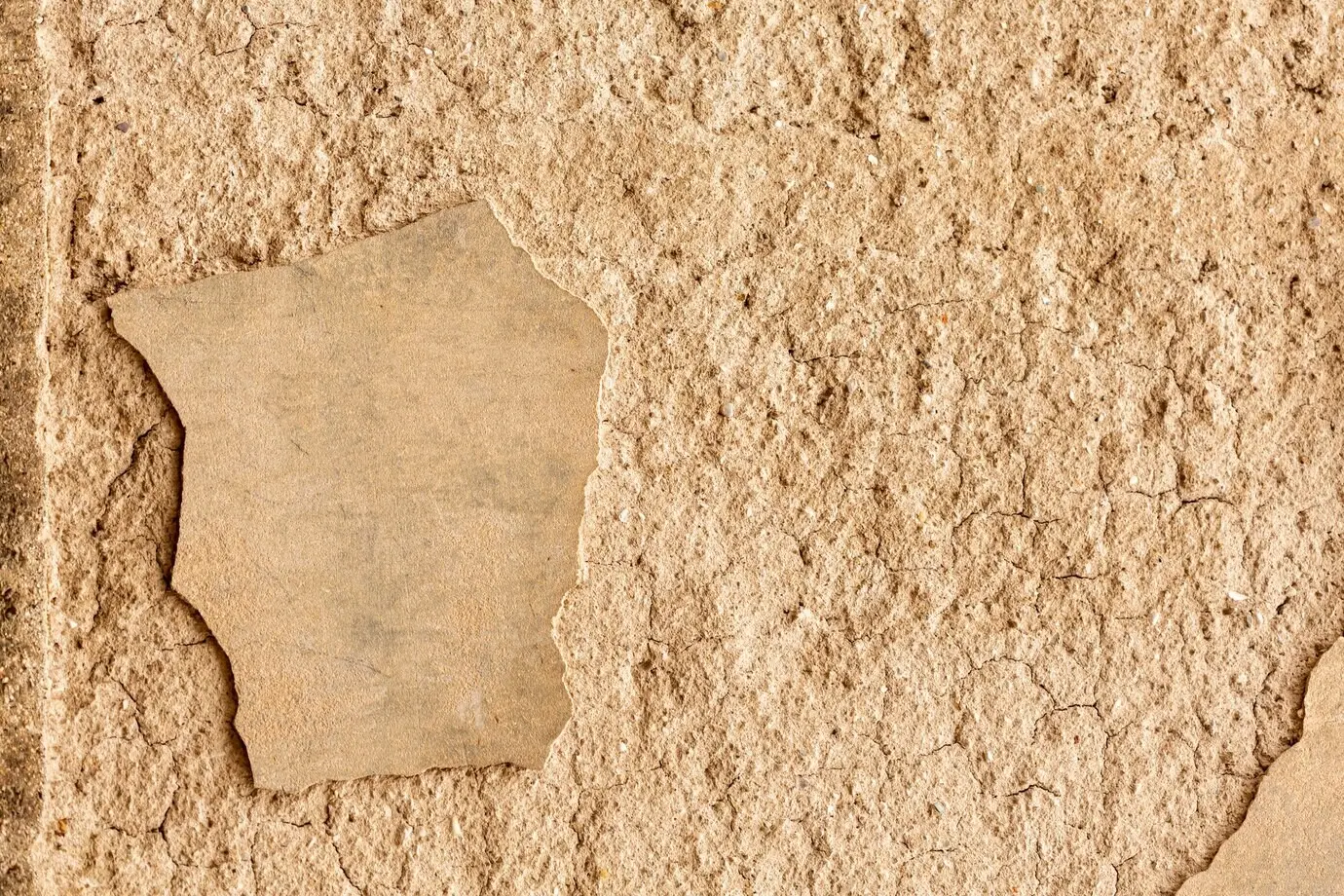 Betonwand mit Rissen und rauer Oberfläche